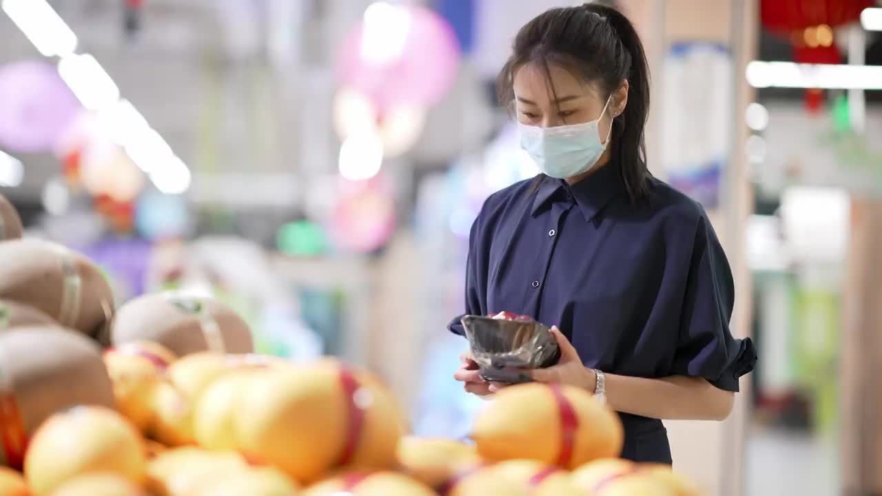 年轻女子在超市里选购水果视频素材