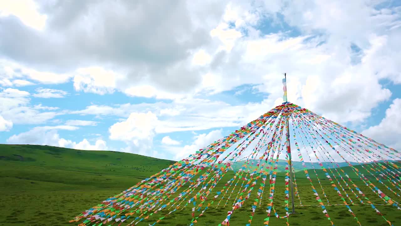 蓝天白云下藏族草原经幡迎风飘扬视频素材