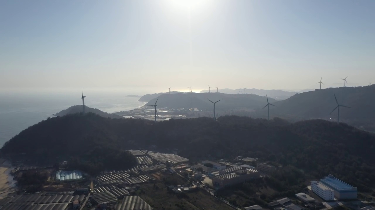 福建漳州东山县东山岛澳角村山顶风力发电机逆光航拍视频素材