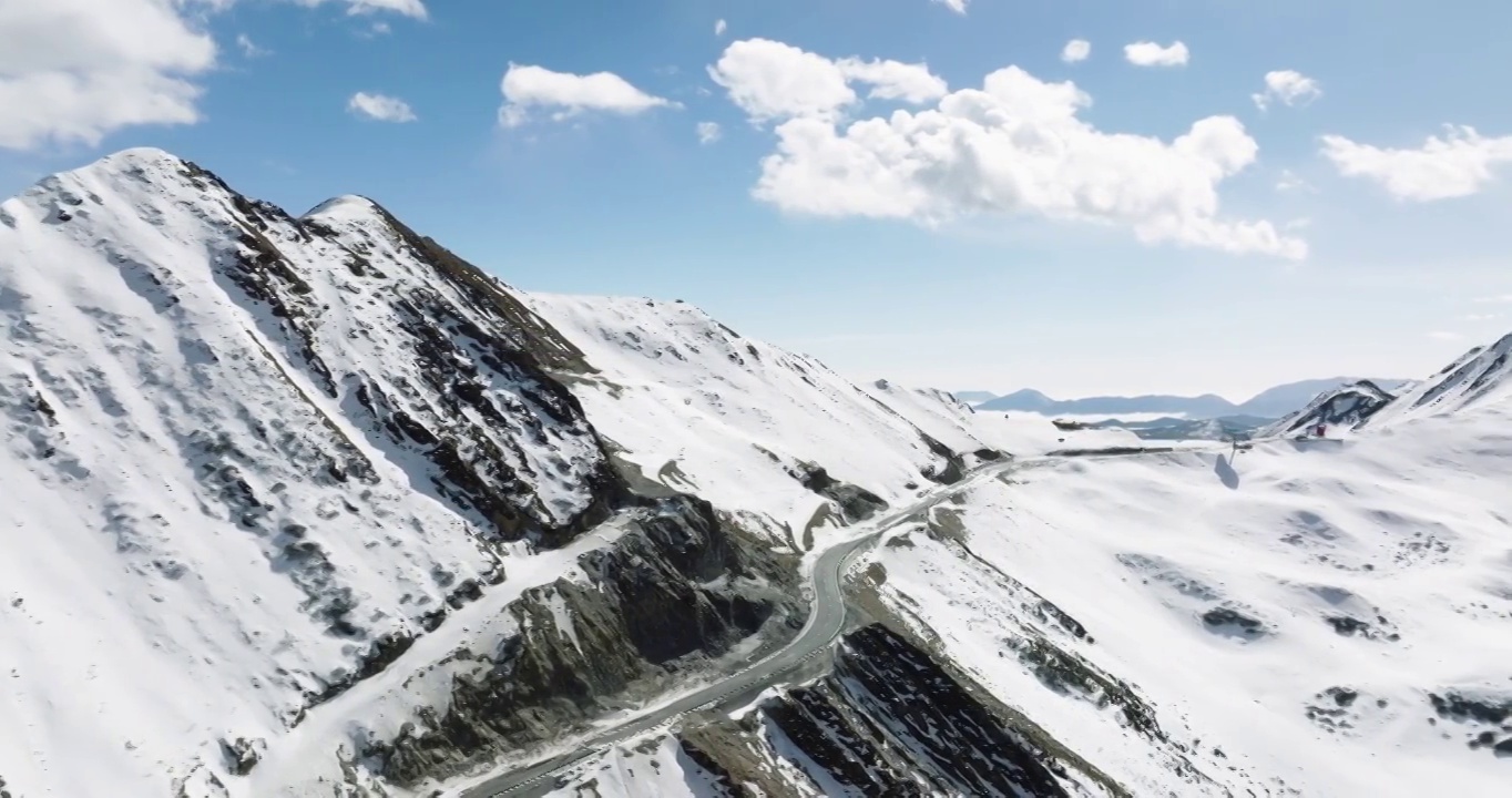 四川阿坝小金县夹金山的航拍风景 蜿蜒的山路在白雪皑皑的山上视频素材