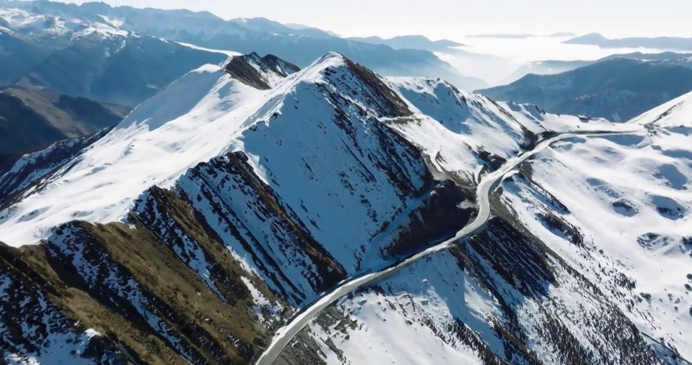 四川阿坝小金县夹金山的航拍风景 蜿蜒的山路在白雪皑皑的山上视频素材