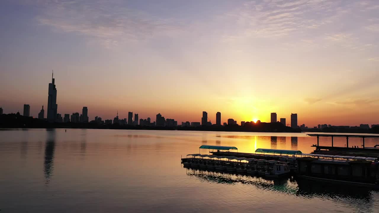 夕阳下的南京玄武湖公园湖景和城市天际线剪影视频素材