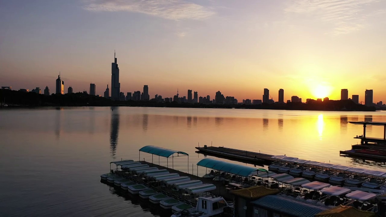 夕阳下的南京玄武湖公园码头和城市天际线日落风光视频素材