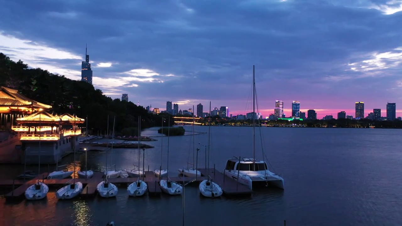 日落时分晚霞中的南京玄武湖公园游艇帆船码头夜景风光视频素材