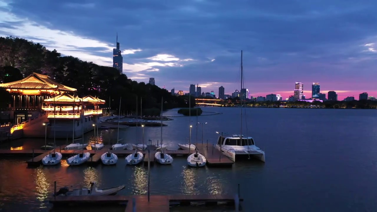 日落时分霞光下的南京玄武湖公园游艇帆船码头夜景风光视频素材