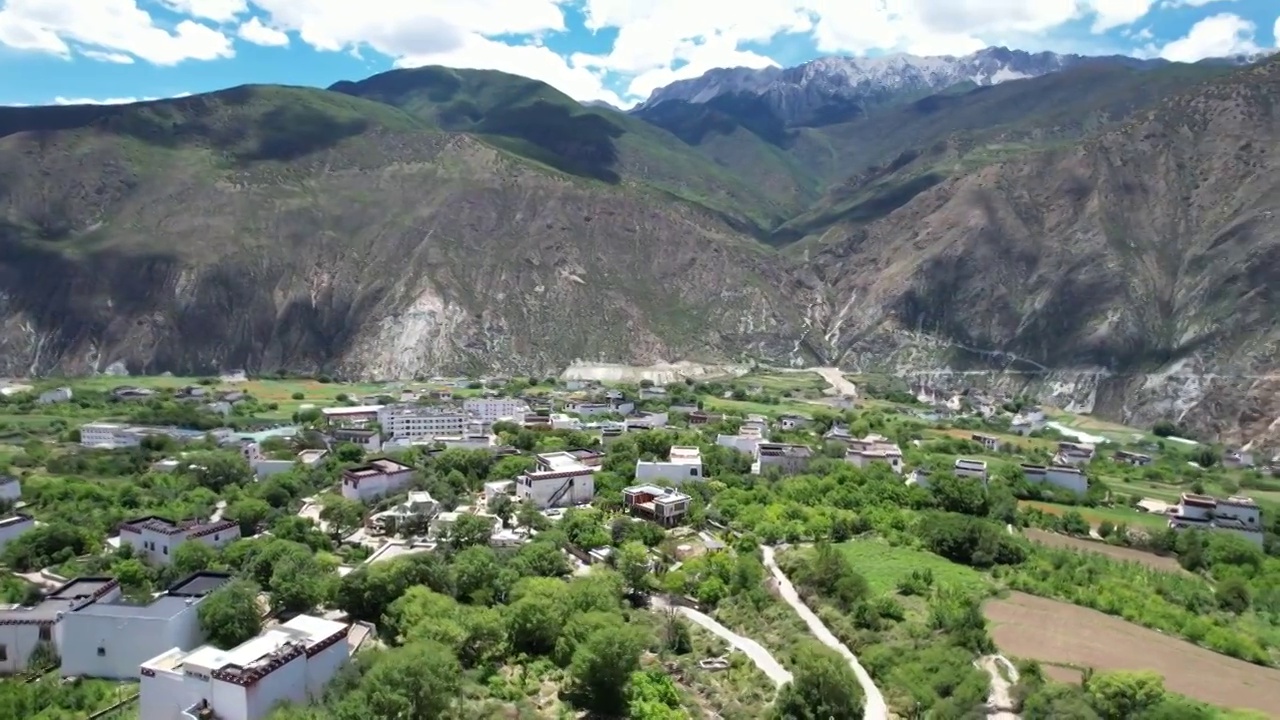 航拍四川川西甘孜州乡城县田园风光，初夏的青稞田白藏房和山谷自然风光。视频素材