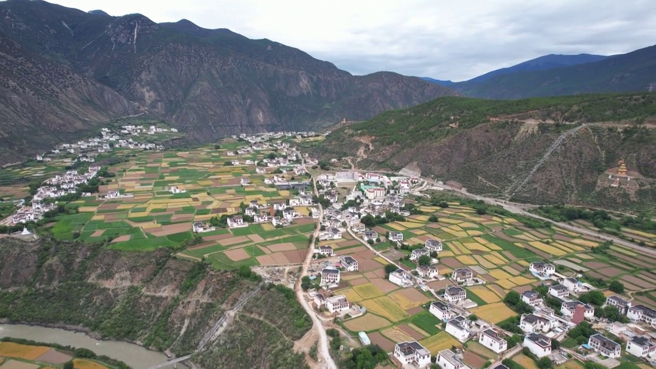 航拍四川川西甘孜州乡城县田园风光，初夏的青稞田白藏房和山谷自然风光。视频素材