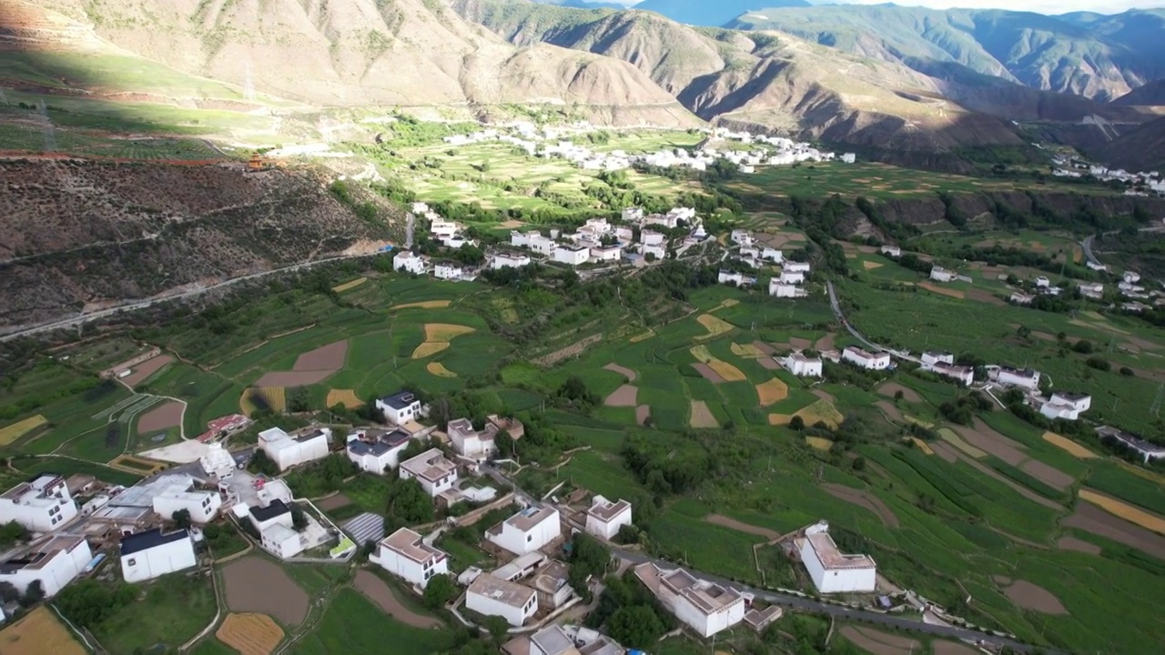 航拍四川川西甘孜州乡城县田园风光，初夏的青稞田白藏房和山谷自然风光。视频素材