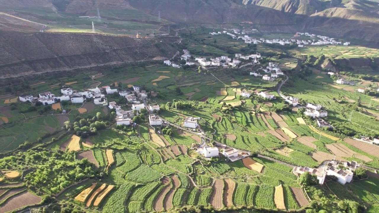 航拍四川川西甘孜州乡城县田园风光，初夏的青稞田白藏房和山谷自然风光。视频素材