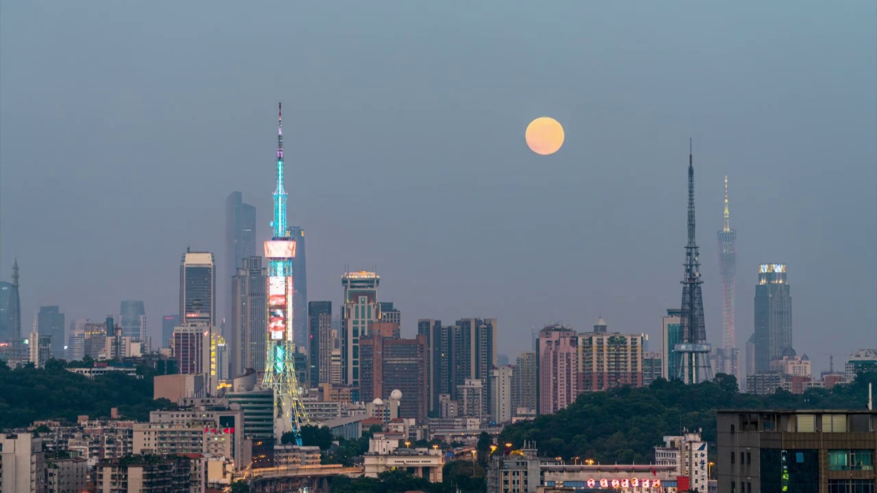 超级月亮在广州的高大楼群塔林中徐徐升起视频素材