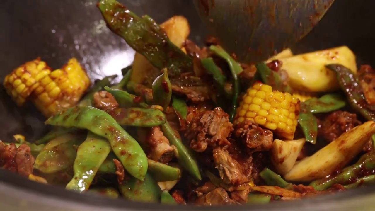 中餐厨师制作铁锅炖排骨豆角玉米视频素材