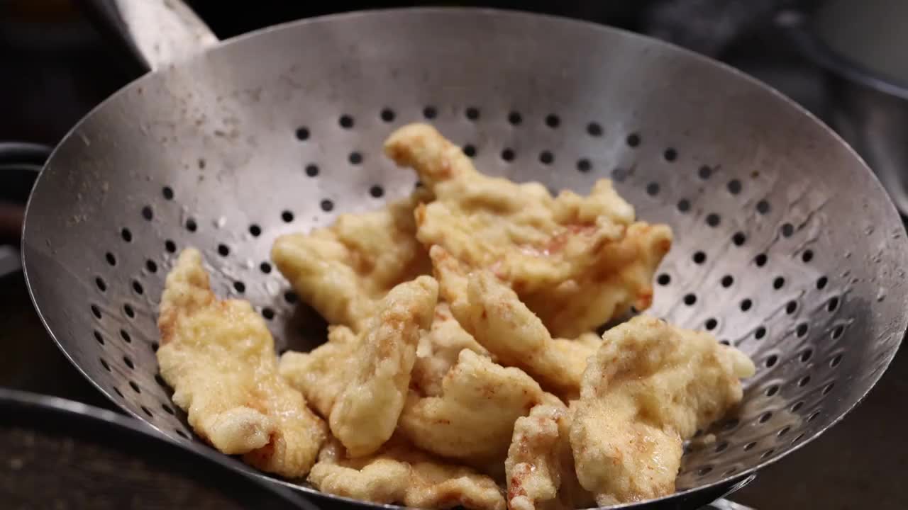 中餐厨师制作东北菜锅包肉高温油锅油炸猪肉慢镜头视频素材