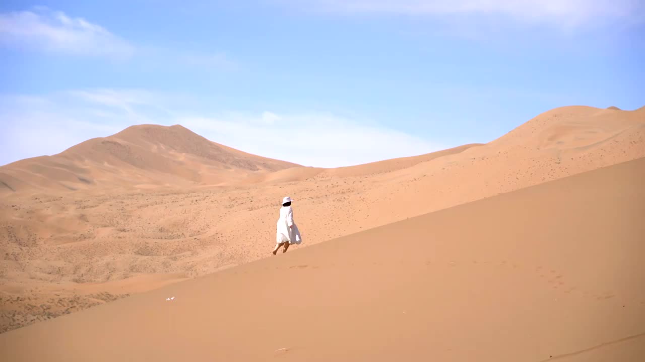 中国西部内蒙古阿拉善巴丹吉林沙漠 在沙漠中行走的旅行者视频素材