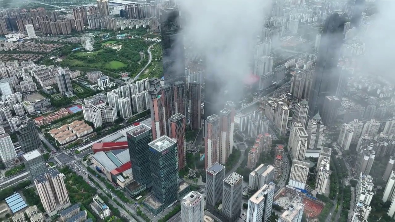 无人机从高空视角，穿过云层，拍摄雨后南宁市中心的城市风光视频下载