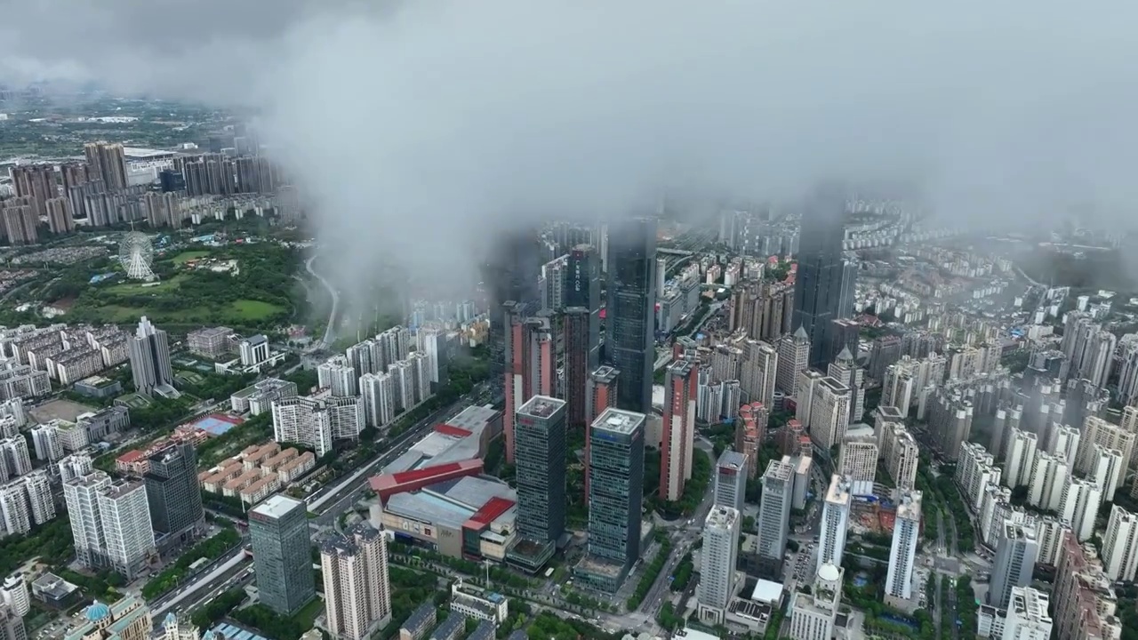 无人机从高空视角，穿过云层，拍摄雨后南宁市中心的城市风光视频下载