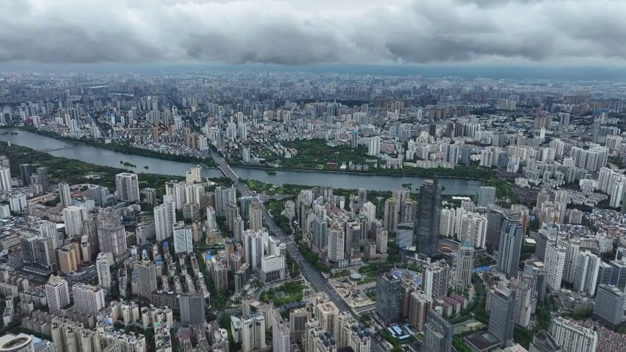 无人机从高空视角，穿过云层，拍摄雨后南宁市中心的城市风光视频下载