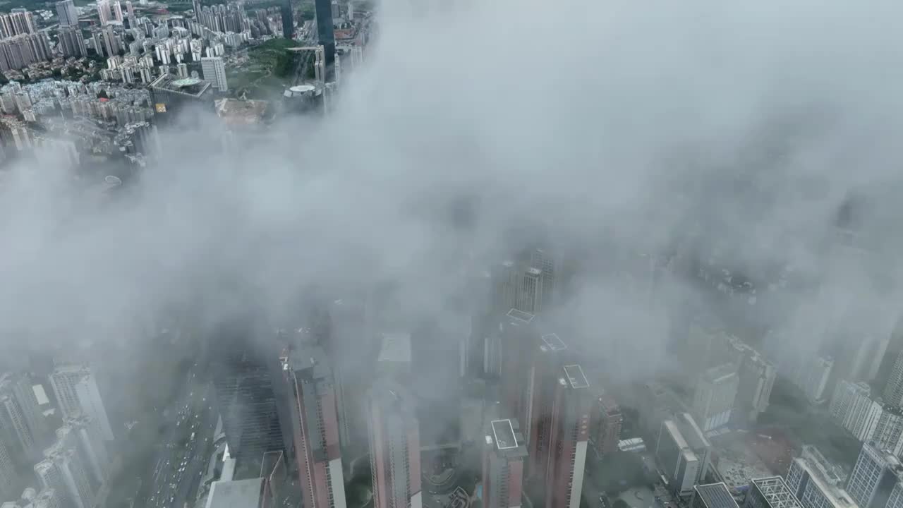 无人机从高空视角，穿过云层，拍摄雨后南宁市中心的城市风光视频下载