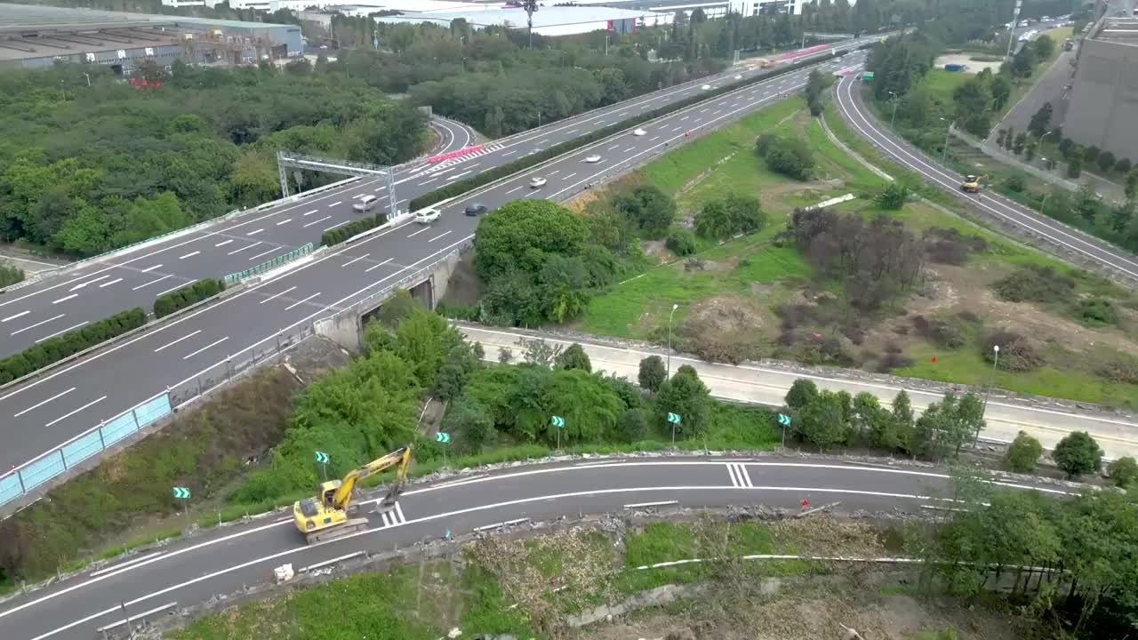 延时航拍成都五环路改造工程：挖掘机在匝道上行驶视频素材