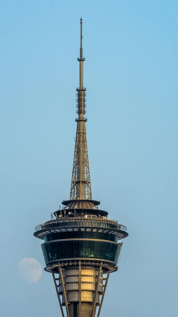 月亮在中国澳门城市旅游塔观光塔旁冉冉升起的壮丽景象视频素材