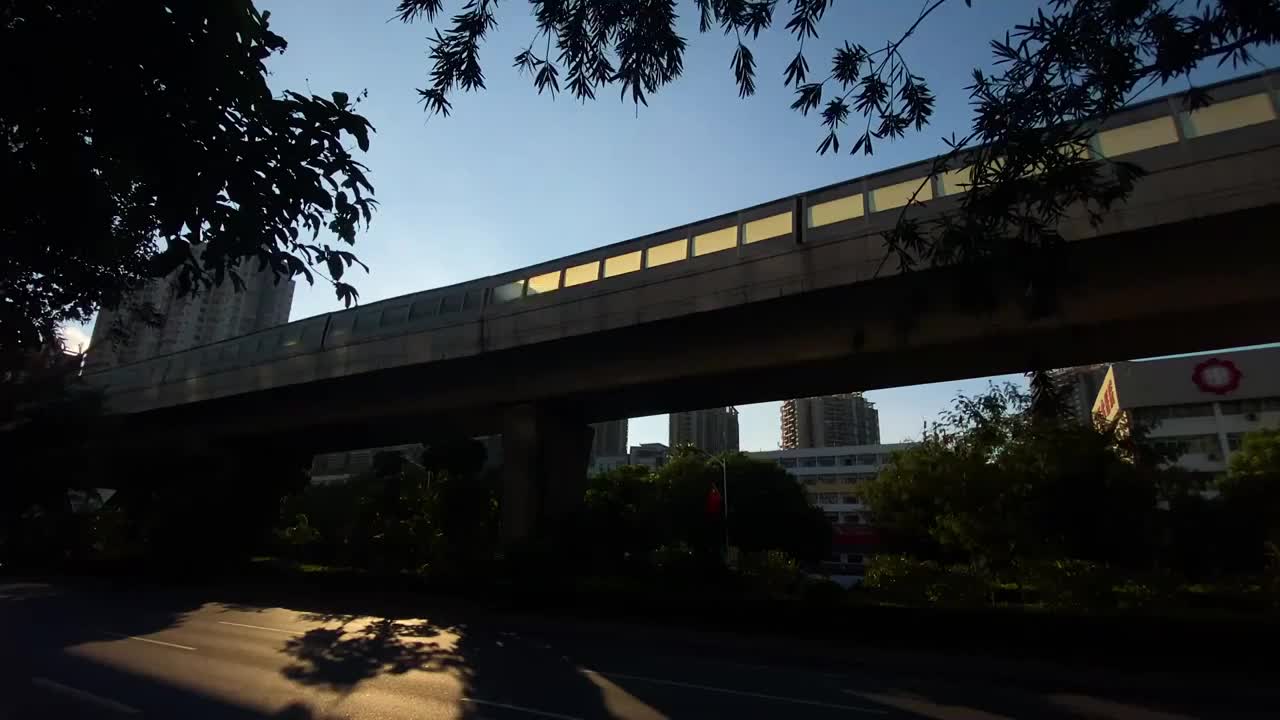 朝阳下运行中的城市地铁运输穿行在城市高楼之间视频素材