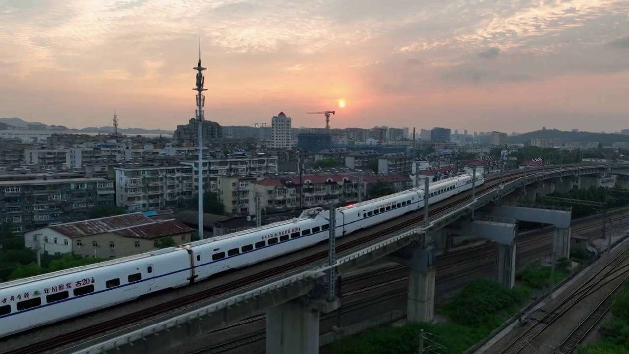 日出阳光下在城市中穿行的高铁火车视频素材