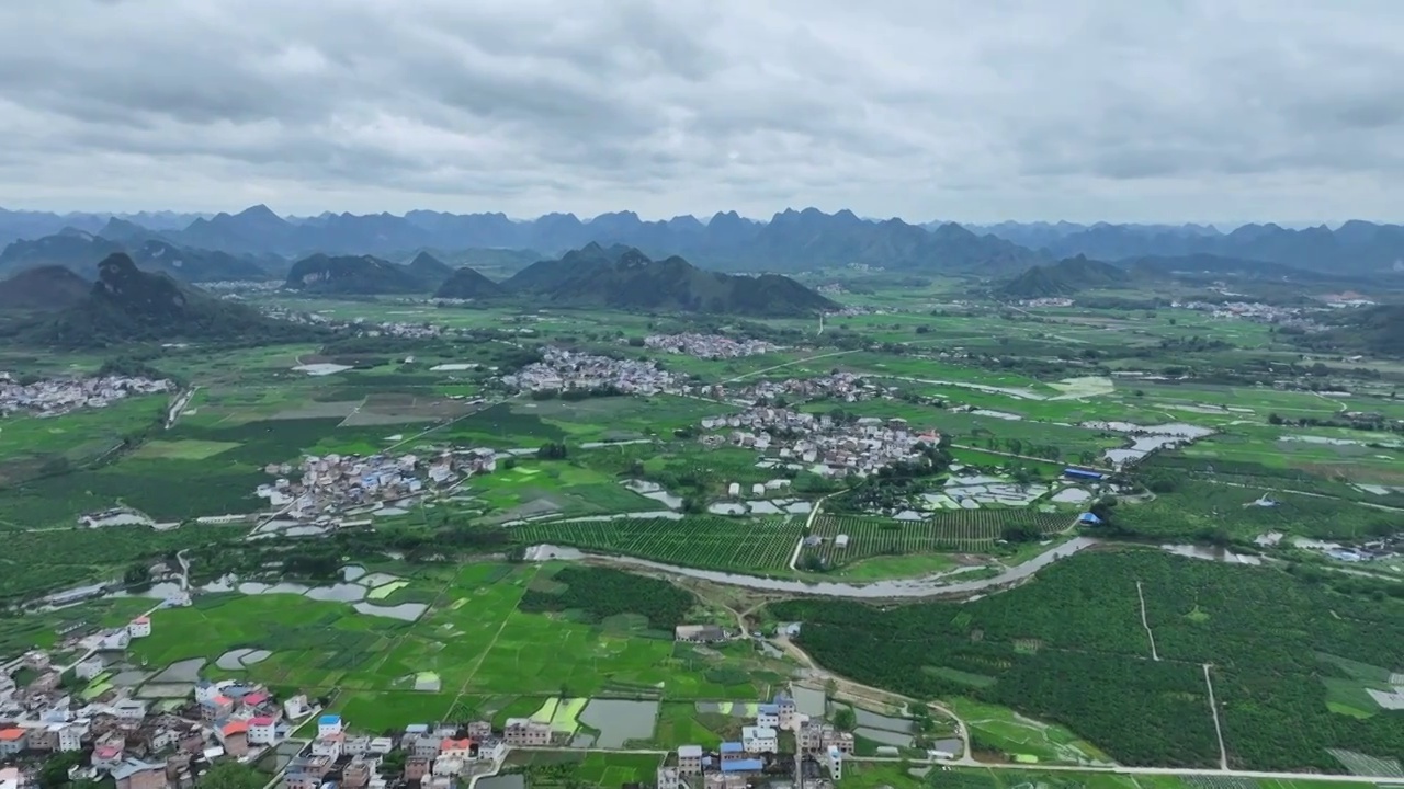 航拍山谷间中国传统村落，春天，稻田里是绿油油的稻苗视频素材