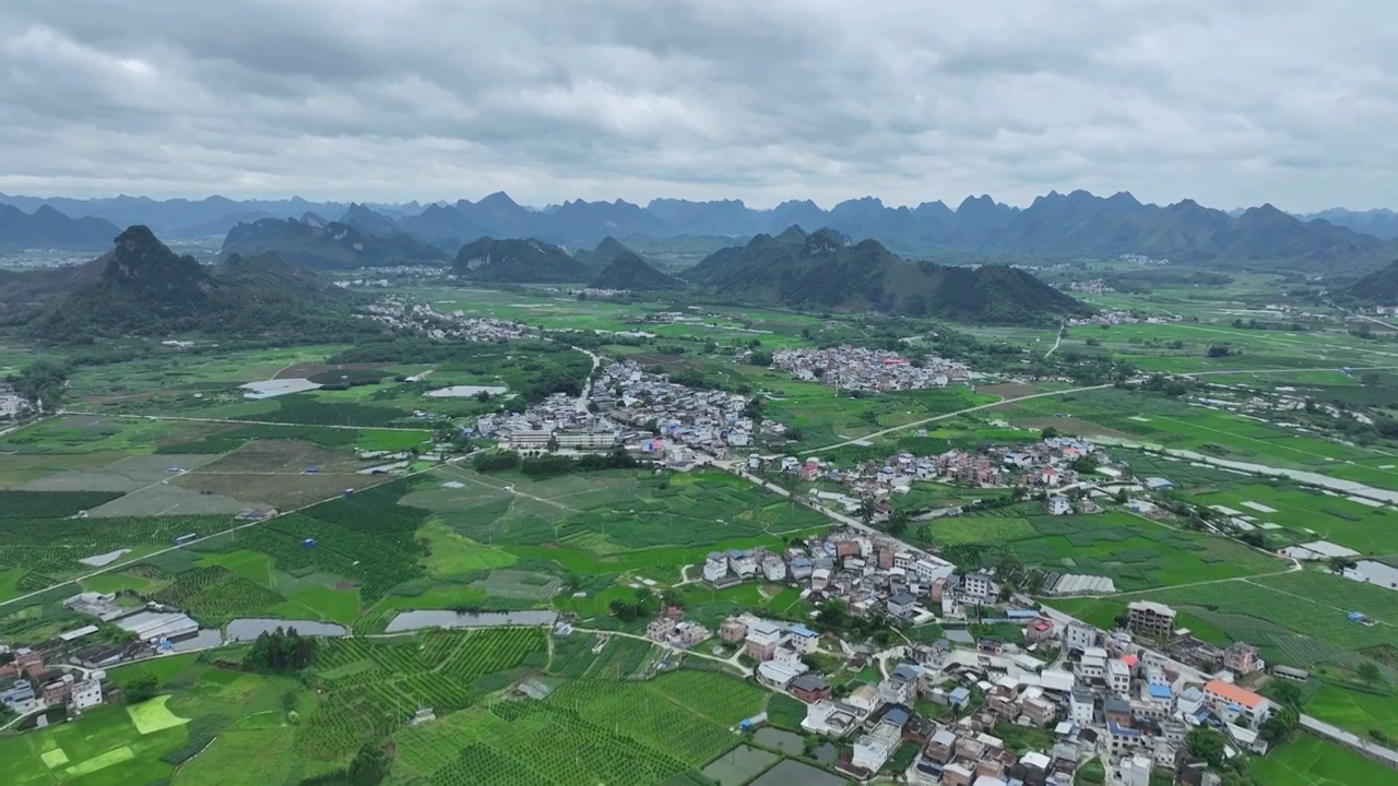 航拍山谷间中国传统村落，春天，稻田里是绿油油的稻苗视频素材