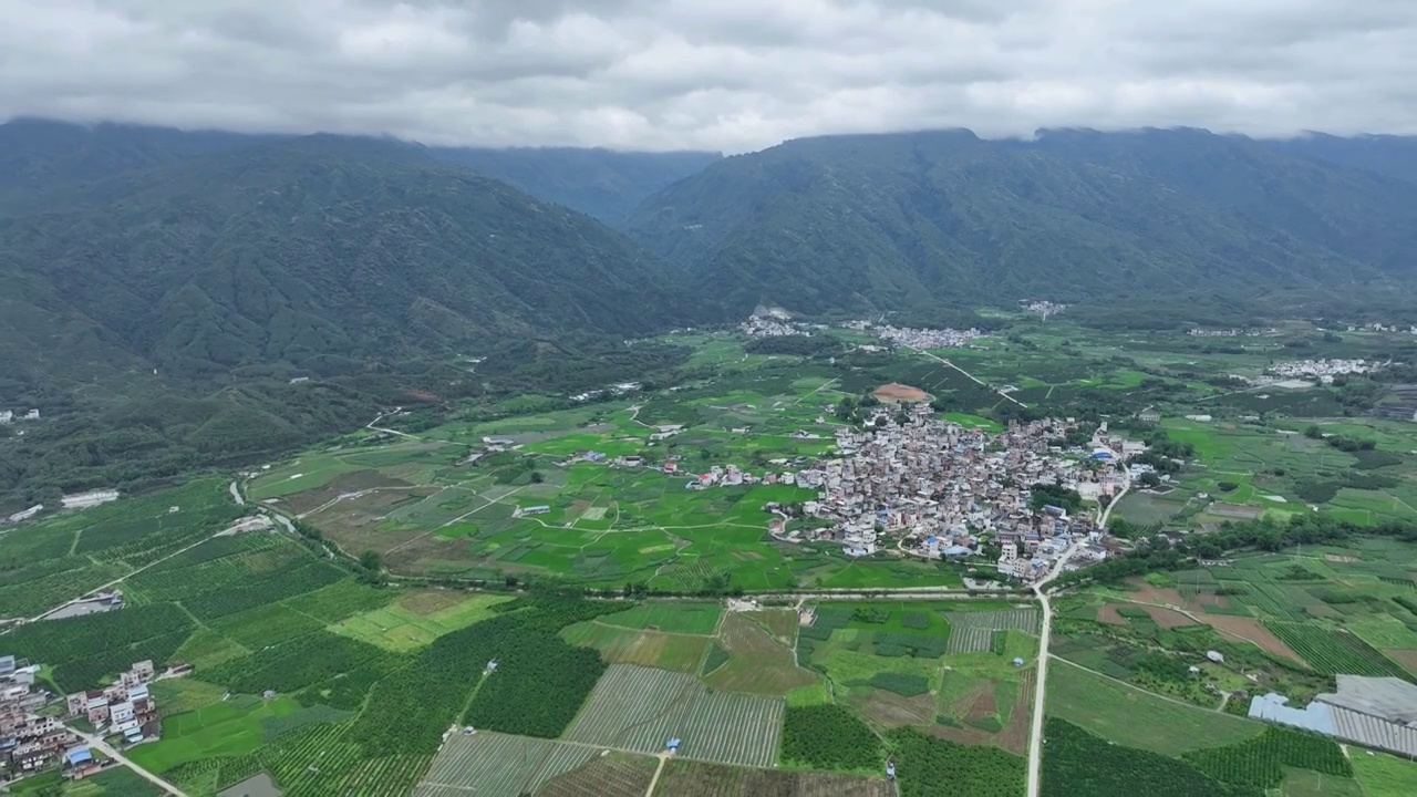 航拍山谷间中国传统村落，春天，稻田里是绿油油的稻苗视频下载