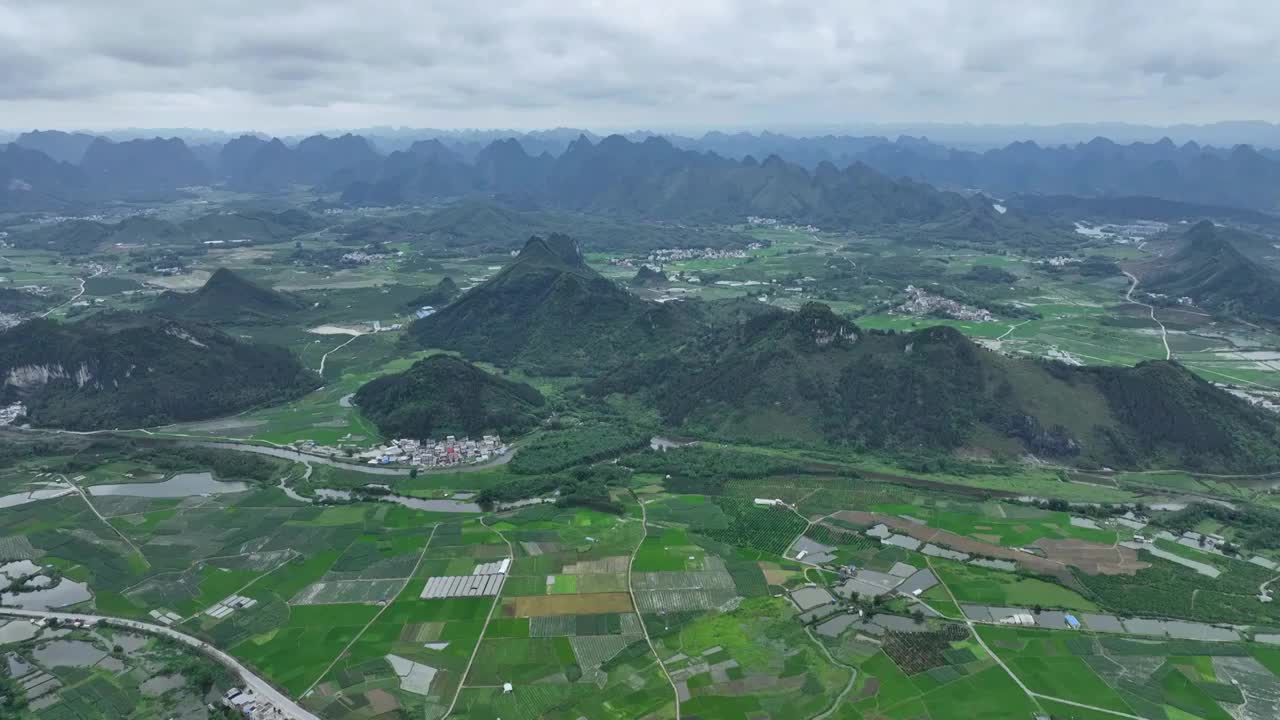 航拍山谷间中国传统村落，春天，稻田里是绿油油的稻苗视频素材