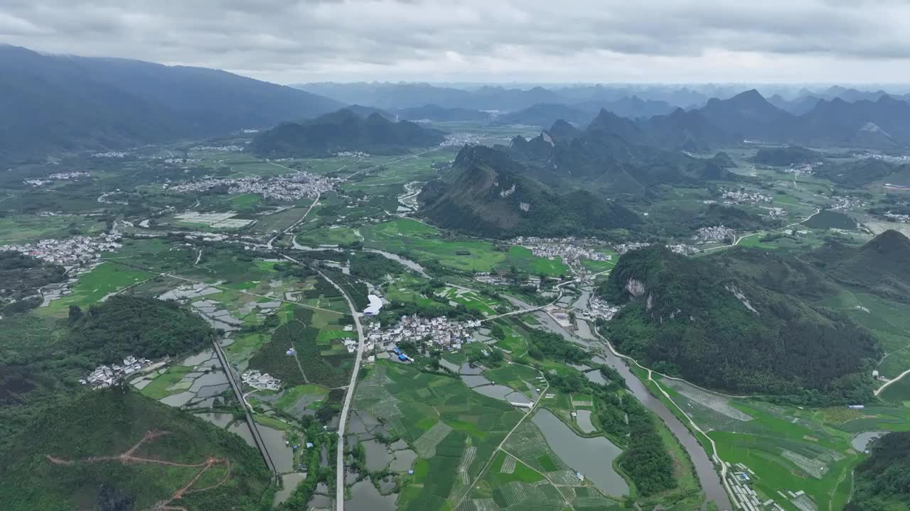 航拍山谷间中国传统村落，春天，稻田里是绿油油的稻苗视频素材