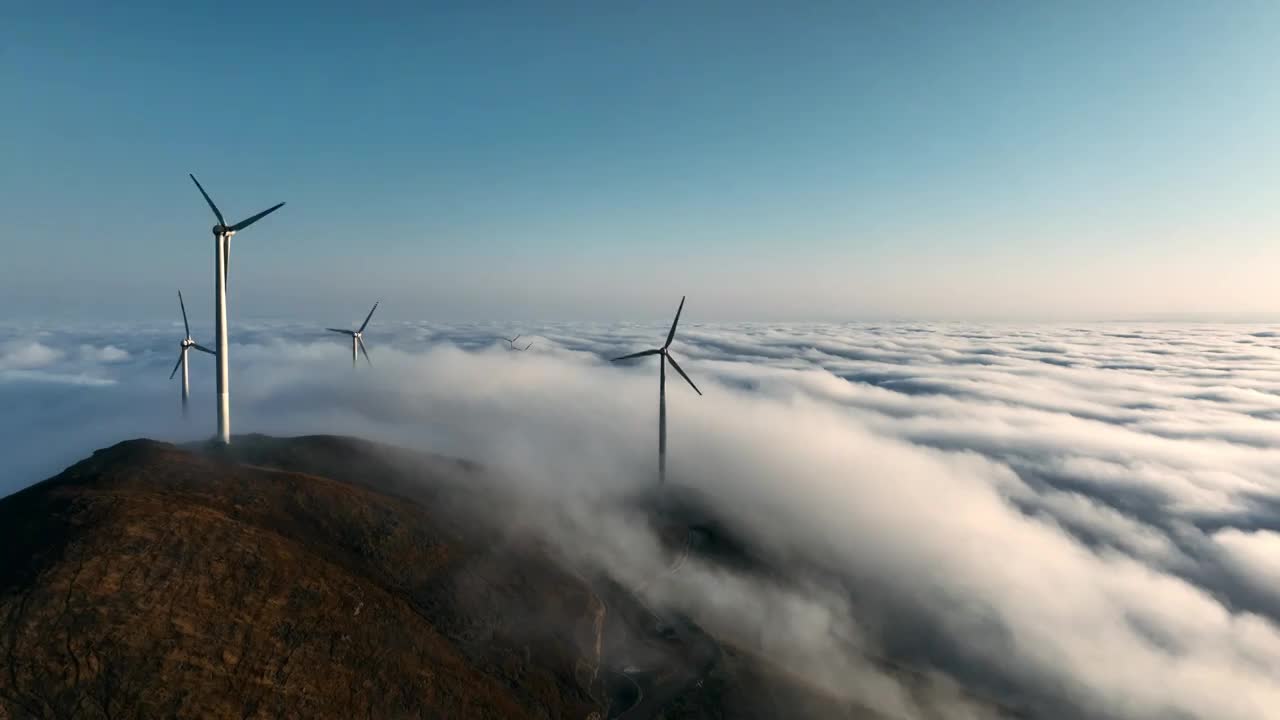 冬季黎明日出时分高山上的云海和风力发电设施视频素材