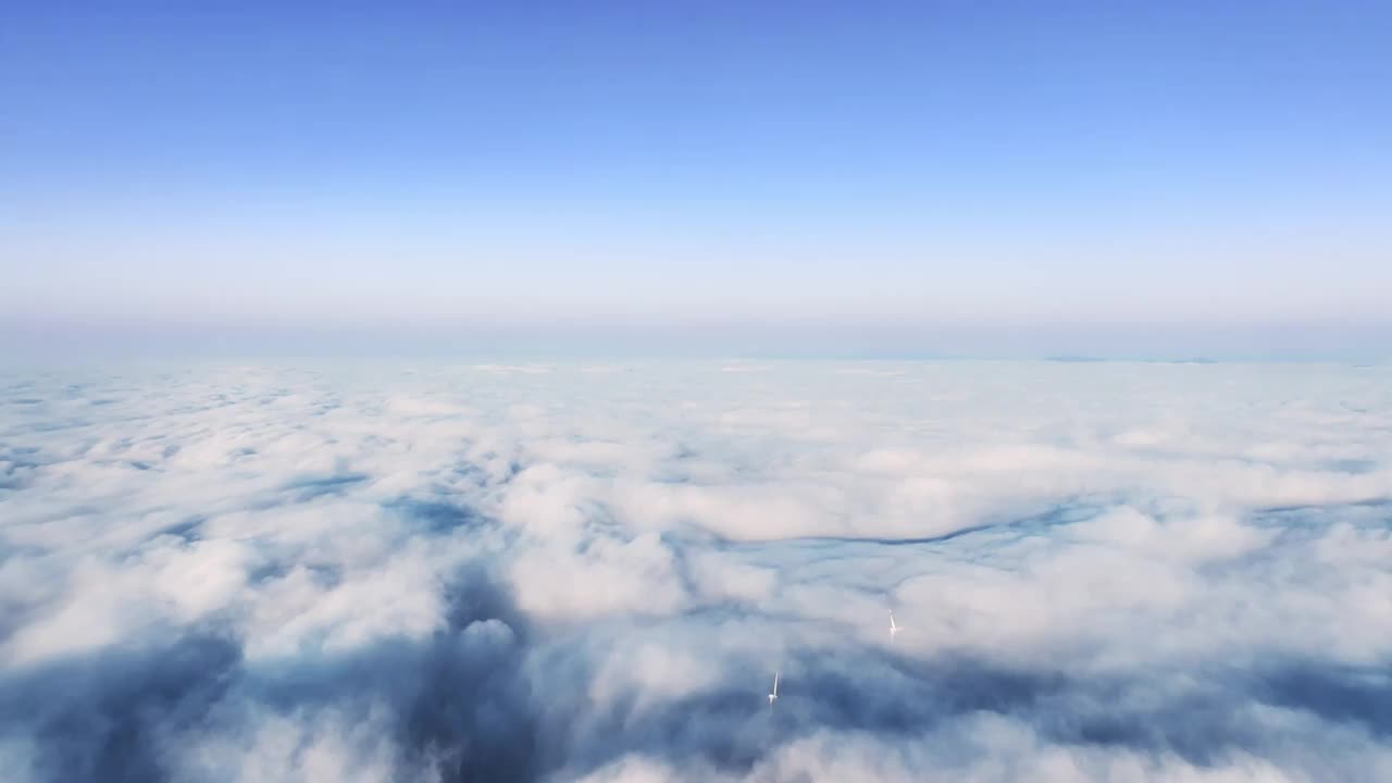 航拍冬季高山上的风力发电风车和山间的云海视频素材