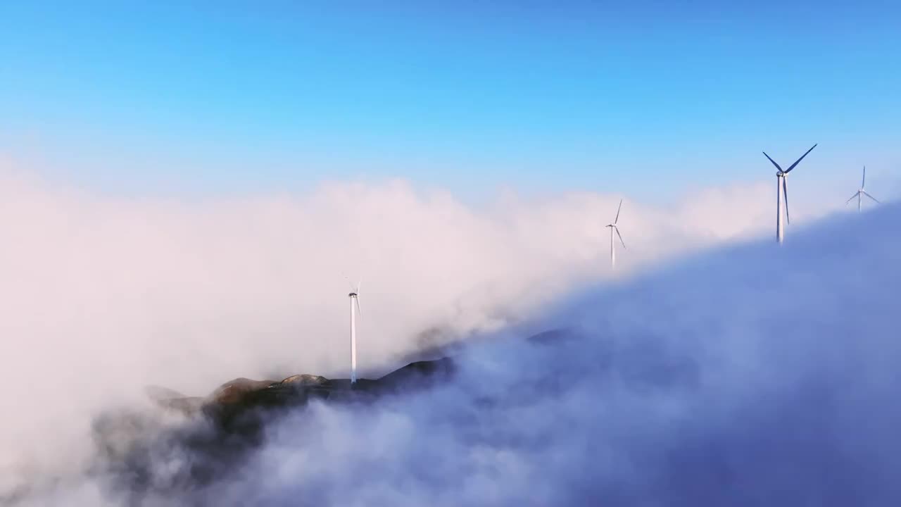 高视角航拍高山顶上的风力发电风车和山间的云海视频素材