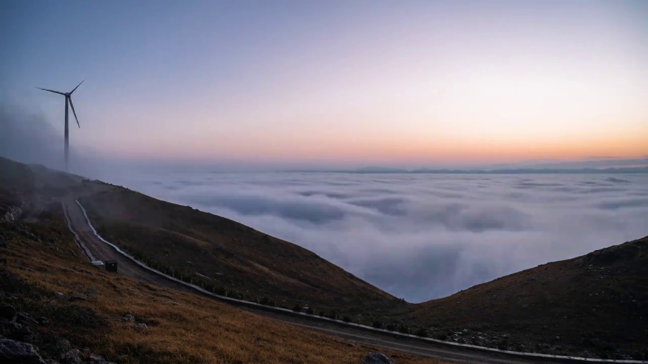 冬季清晨高山上的风力发电风车和山谷中的云海视频素材