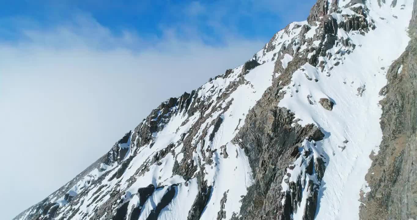 无人机贴着山脊飞行雪山蓝天航拍风景视频素材