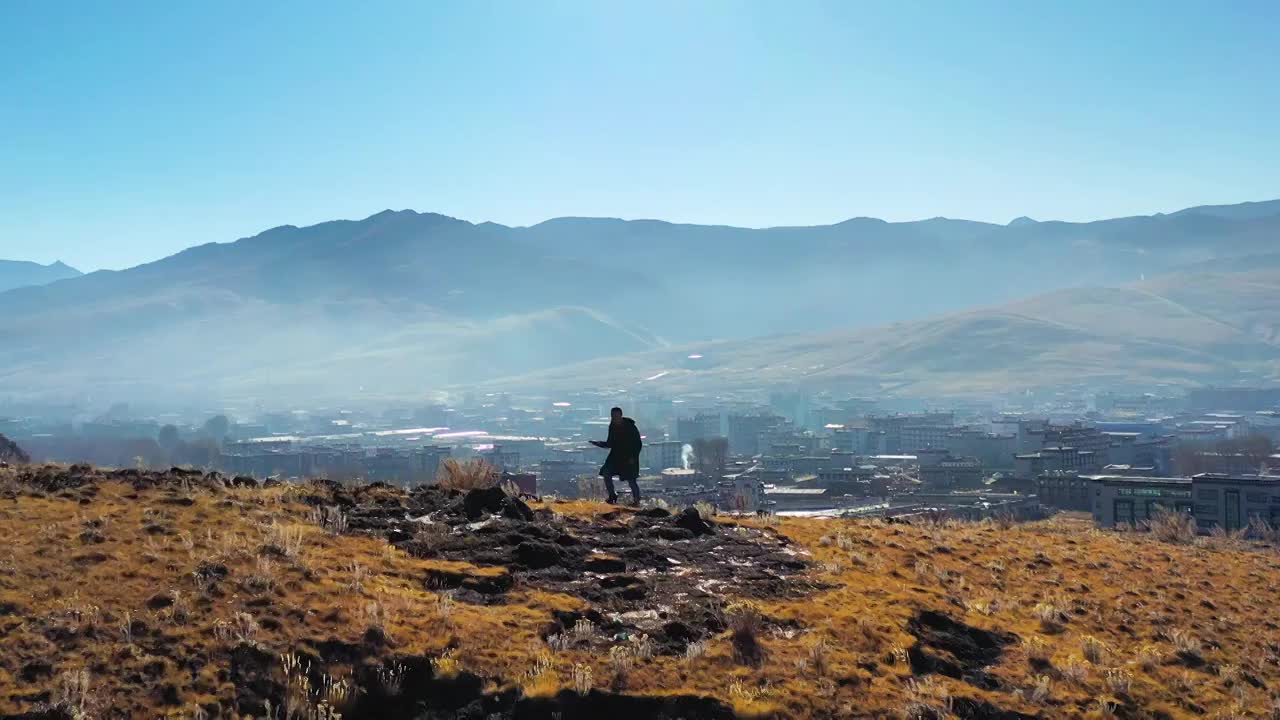 航拍甘孜稻城县旅人在山坡上徒步景象视频素材