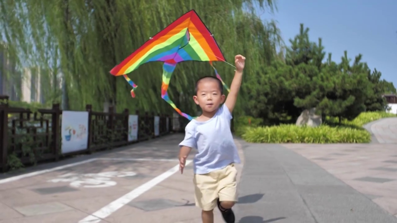 中国小朋友在公园树林中放风筝视频素材画面3