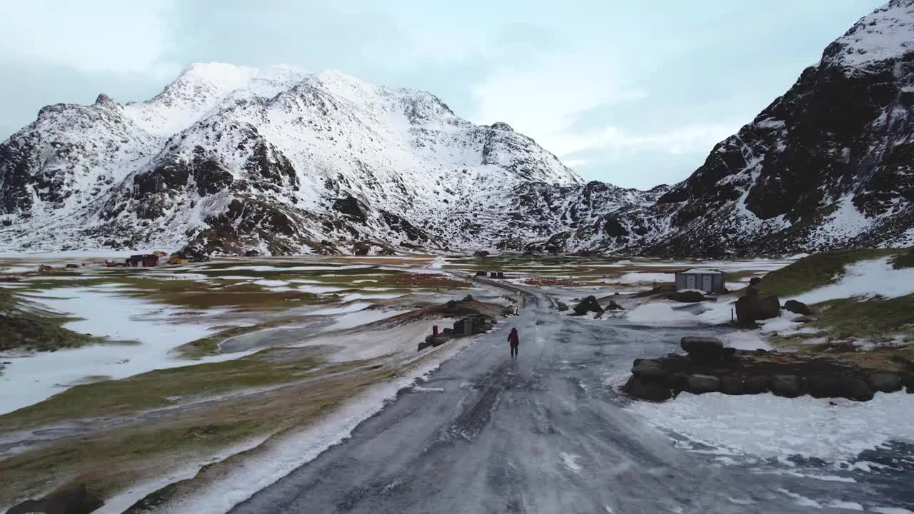 航拍挪威罗弗敦群岛冬季自然风光，一个人走在结冰的道路上视频素材