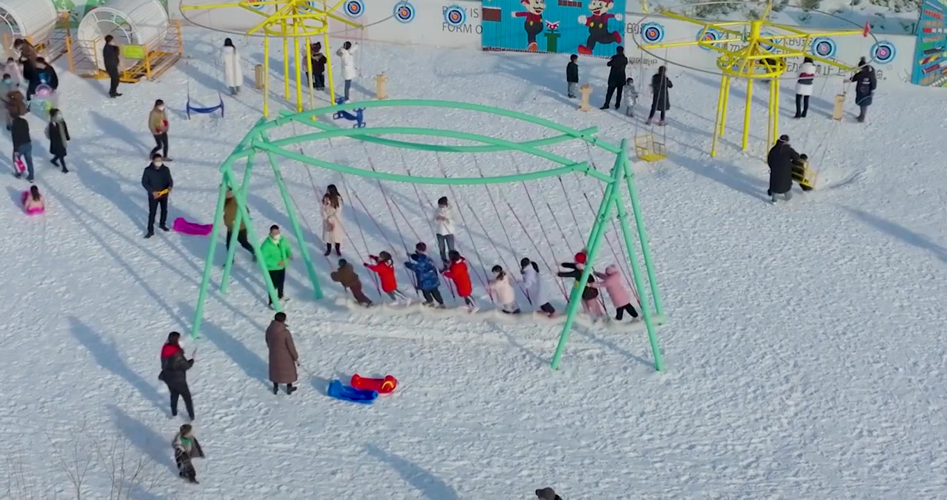航拍空中鸟瞰滑雪场上市民带着孩子儿童在滑雪玩雪上游戏视频素材画面2