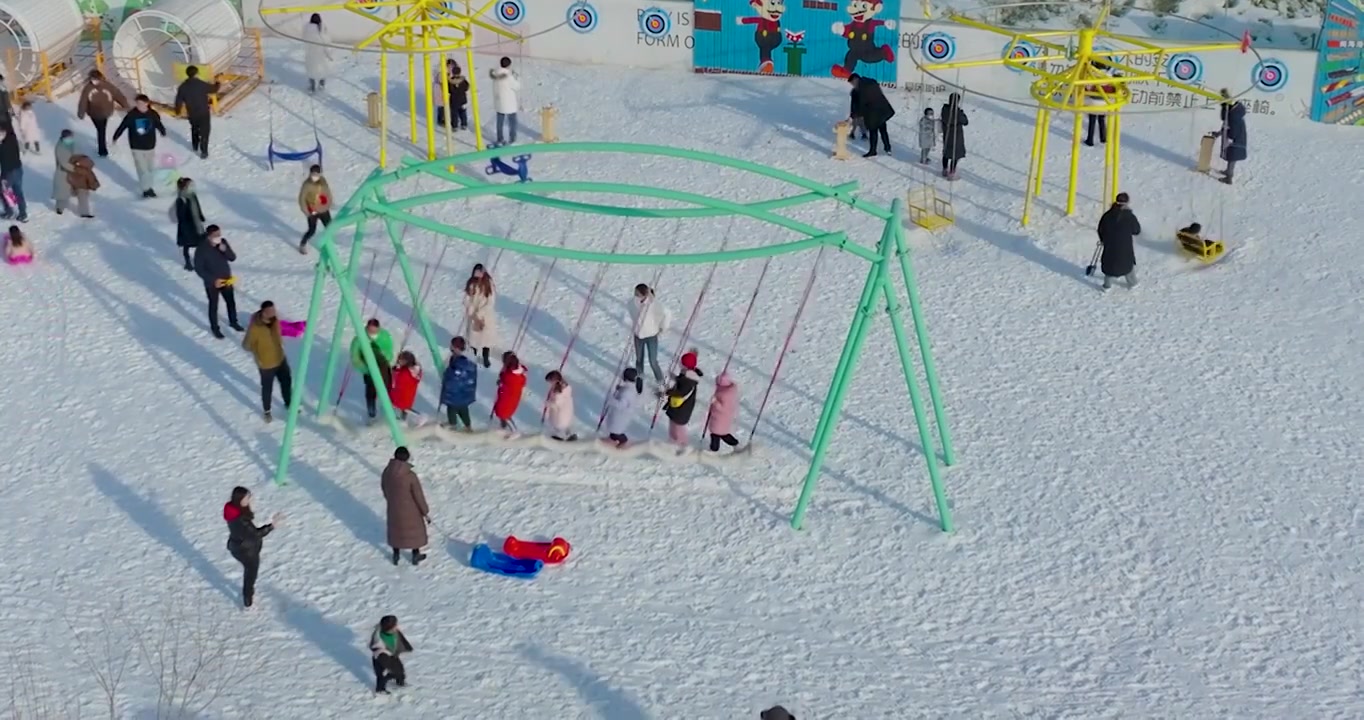 航拍空中鸟瞰滑雪场上市民带着孩子儿童在滑雪玩雪上游戏视频素材画面3