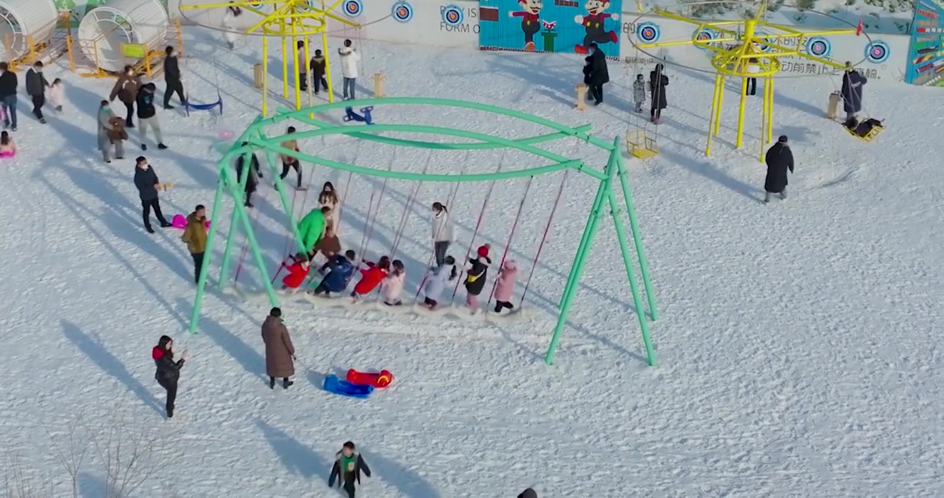 航拍空中鸟瞰滑雪场上市民带着孩子儿童在滑雪玩雪上游戏视频素材画面4