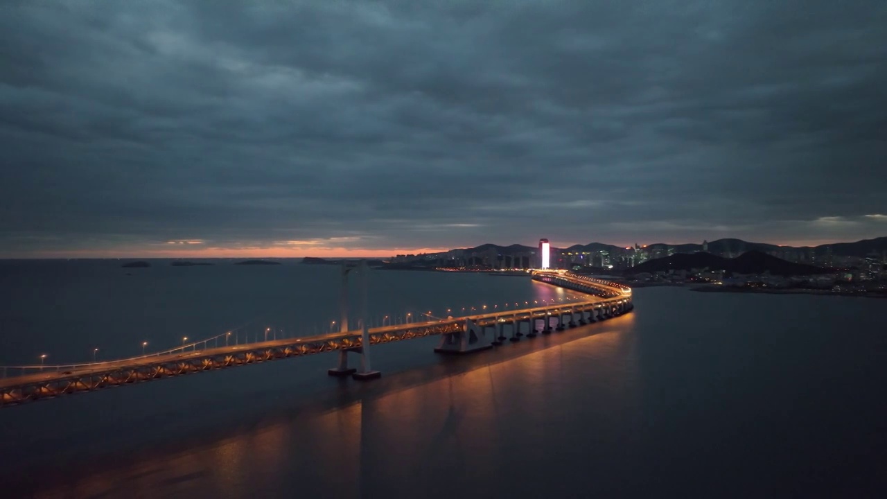 大连星海湾大桥和星海广场和摩天轮和贝壳博物馆的黄昏日落晚霞夜景和穿越跨海大桥特写视频视频素材