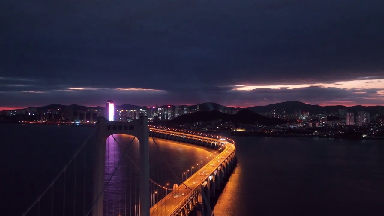 大连星海湾大桥和星海广场和摩天轮和贝壳博物馆的黄昏日落晚霞夜景和穿越跨海大桥特写视频视频素材