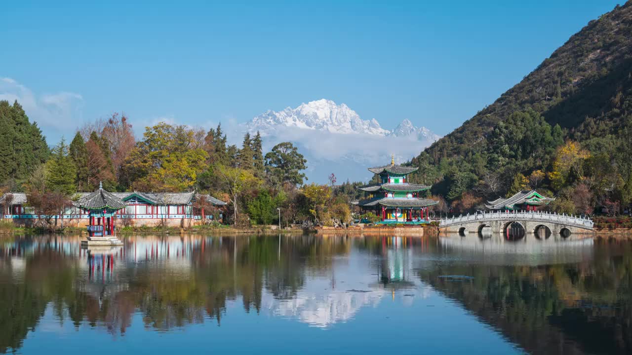 云南丽江市黑龙潭公园和玉龙雪山白昼晴天延时摄影视频素材