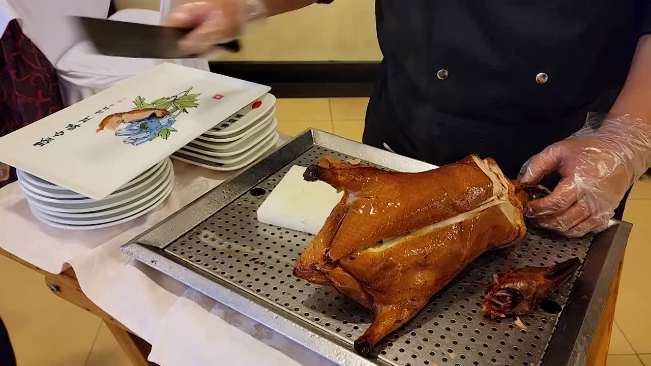 餐厅厨师正在将加工好的烤鸭切片装盘视频素材