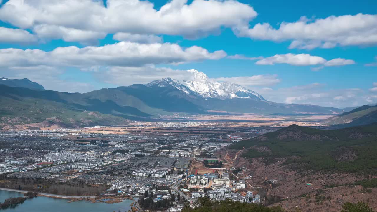 云南丽江束河古镇和玉龙雪山蓝天白云光影白昼晴天延时摄影视频素材