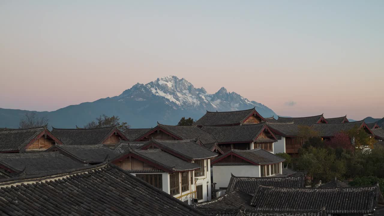 云南丽江古城房屋客栈和玉龙雪山日出日照金山延时摄影视频素材