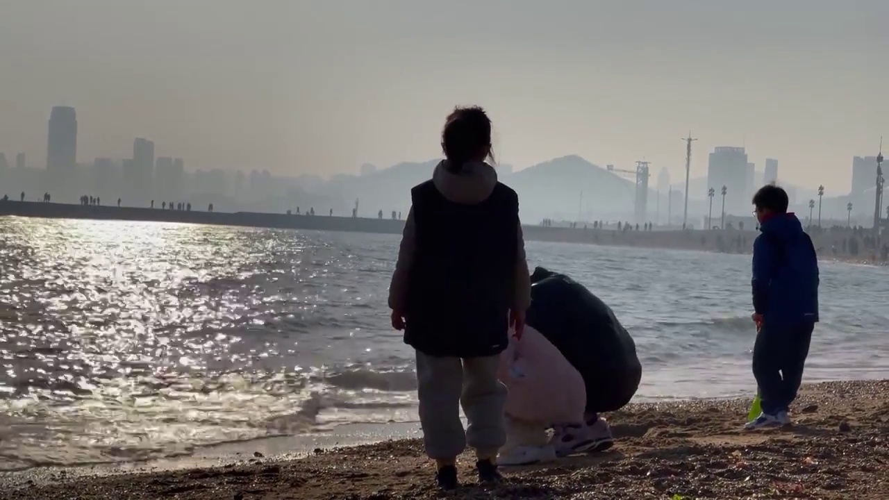 一家人在海边投石子玩耍视频素材