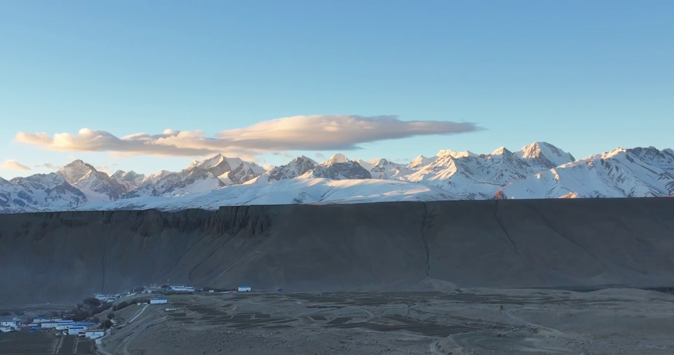 航拍广阔的大地村庄与远处的雪山视频素材