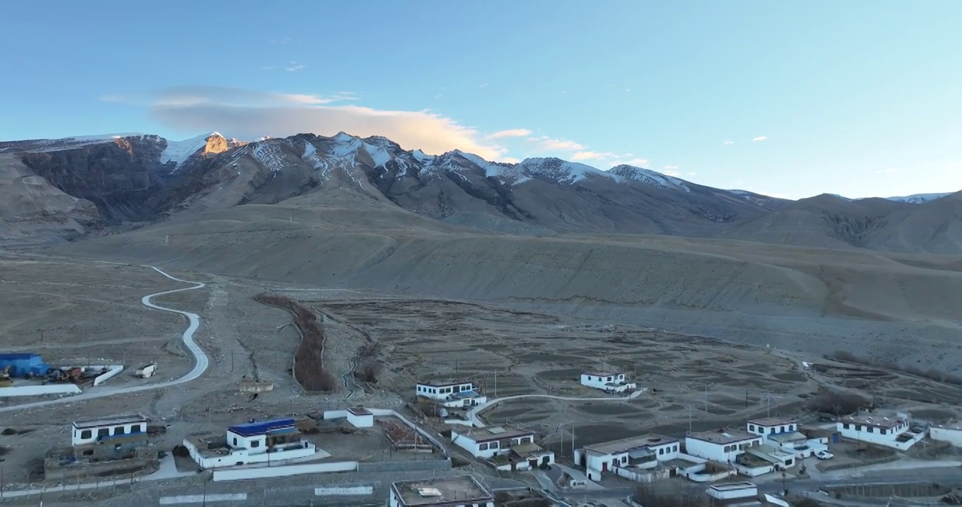 航拍广阔的大地村庄与远处的雪山视频素材